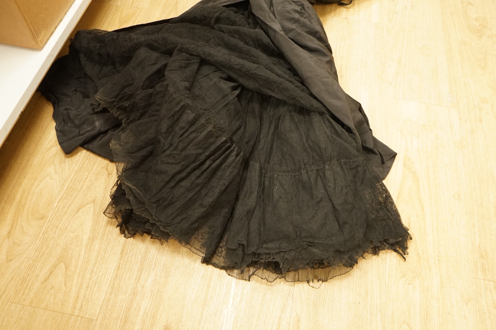 A late 1940’s black lace evening dress, a similar evening dress with black velvet ribbon detail, a maroon brocade halter neck evening dress and a dark mustard early 1950’s evening silk duster coat.